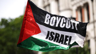 פעילים פרו פלסטינים פרו-פלסטינים מ Palestine Action עם דגל BDS הקורא ל חרם על ישראל בהפגנה מחוץ לבית המשפט ב לונדון נגד הכרזה על הארגון כארגון טרור בריטניה 
