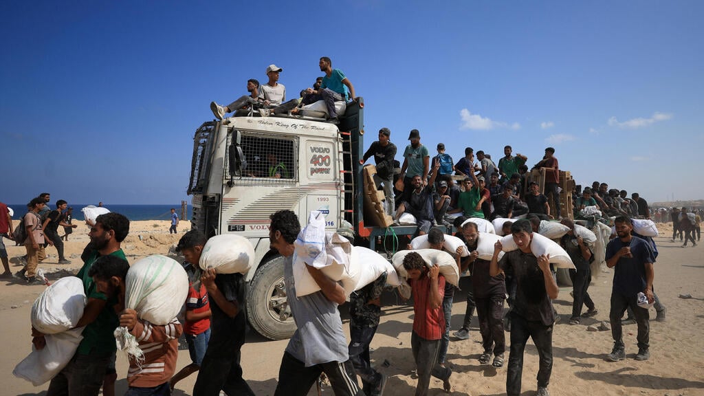Gazans grabbing aid from truck in Gaza (Photo: REUTERS/Dawoud Abu Alkas ) פינוי תושבים ברצועת עזה