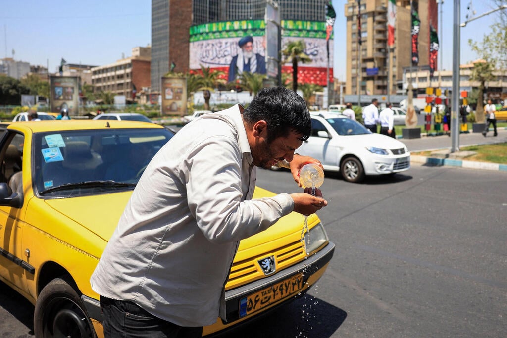 A man cools off with water on a hot day in Tehran, Iran, amid an ongoing heatwave affecting much of the country (Photo: AFP) איראן טהרן גל חום