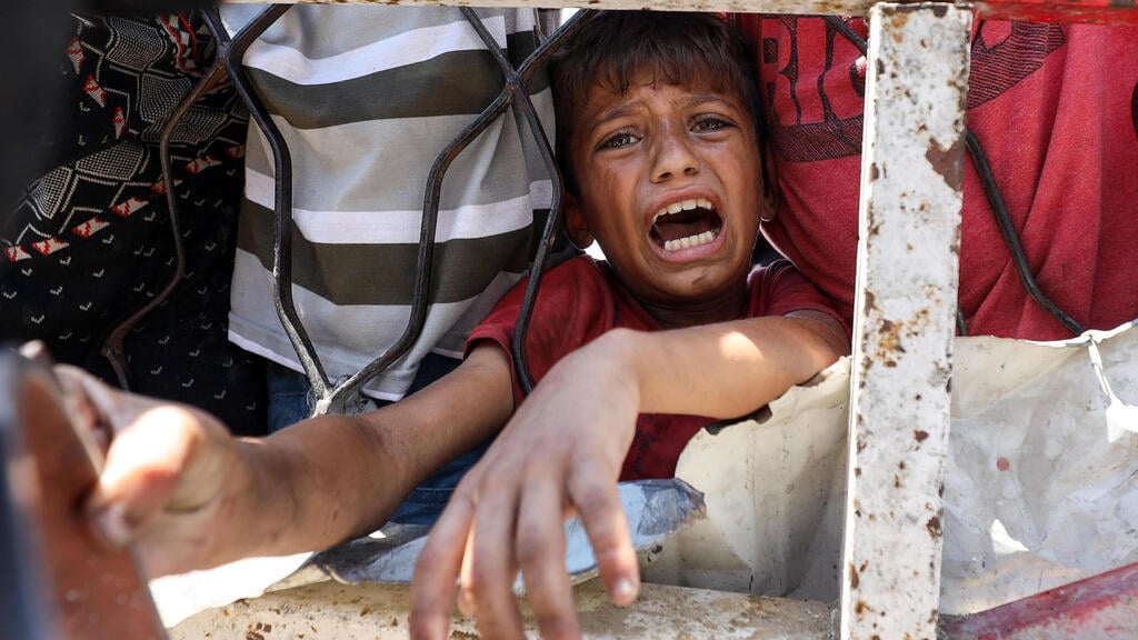 Photo: Khamis Al-Rifi/ Reuters ילד תור ל מזון בעיר עזה בצל טענות למשבר רעב תת-תזונה ברצועה