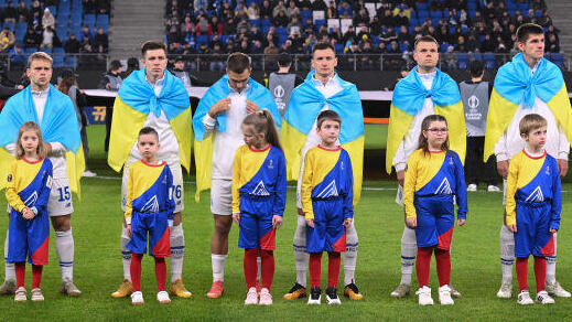 שחקני דינמו קייב מתעטפים בדגלי אוקראינה לפני משחק בליגה האירופית בעונה שעברה