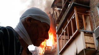 פצוע וברקע האש שעדיין בוערת, בזירת אחת הפגיעות בקייב, היום אוקראינה קייב הפצצה שביצעה רוסיה פצוע