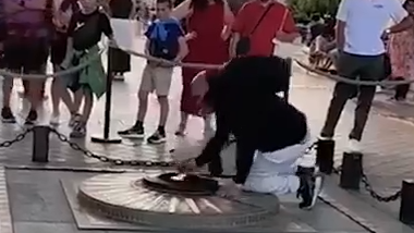 מהגר מרוקני ב צרפת מדליק סיגריה מאש התמיד באנדרטת החייל האלמוני שמתחת ל שער הניצחון ב פריז