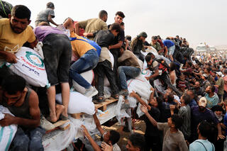 פלסטינים מתנפלים על משאית סיוע המוניטרי חאן יונס עזה פלסטינים מתנפלים על משאית סיוע המוניטרי חאן יונס עזה