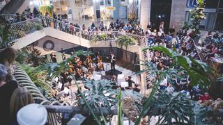 מופע בבניין כלל, הקהל עומד לאורך הספירלה המאפיינת את הפנים