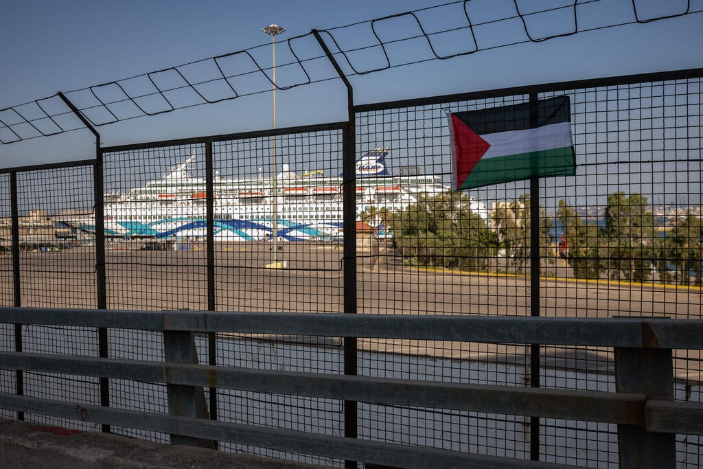 דגל פלסטין תלוי על הגדר כשברקע ה"קראון איריס", אשתקד בכרתים (צילום: Angelos TZORTZINIS / AFP) מחאה פרו פלסטינית ביוון