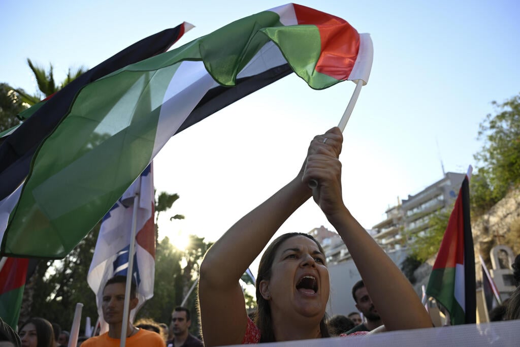 מפגינה מניפה את הדגל הפלסטיני מול "קראון איריס" בנובמבר האחרון (צילום: AP Photo/Michael Varaklas) מחאה פרו פלסטינית ביוון
