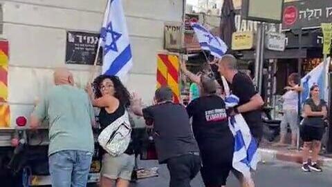 מפגינים עוזרים לדחוף משאית שנתקעה בהוד השרון, לאחר שהנהג איים עליהם