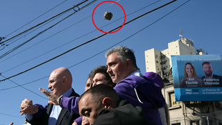 אבן מתעופפת מעל ראשם של מיליי ואנשיו, אמש בבואנוס איירס נשיא ארגנטינה חאבייר מיליי אירוע ה בחירות ב בואנוס איירס שבו הותקפה שיירתו ב אבנים אבן מתעופפת