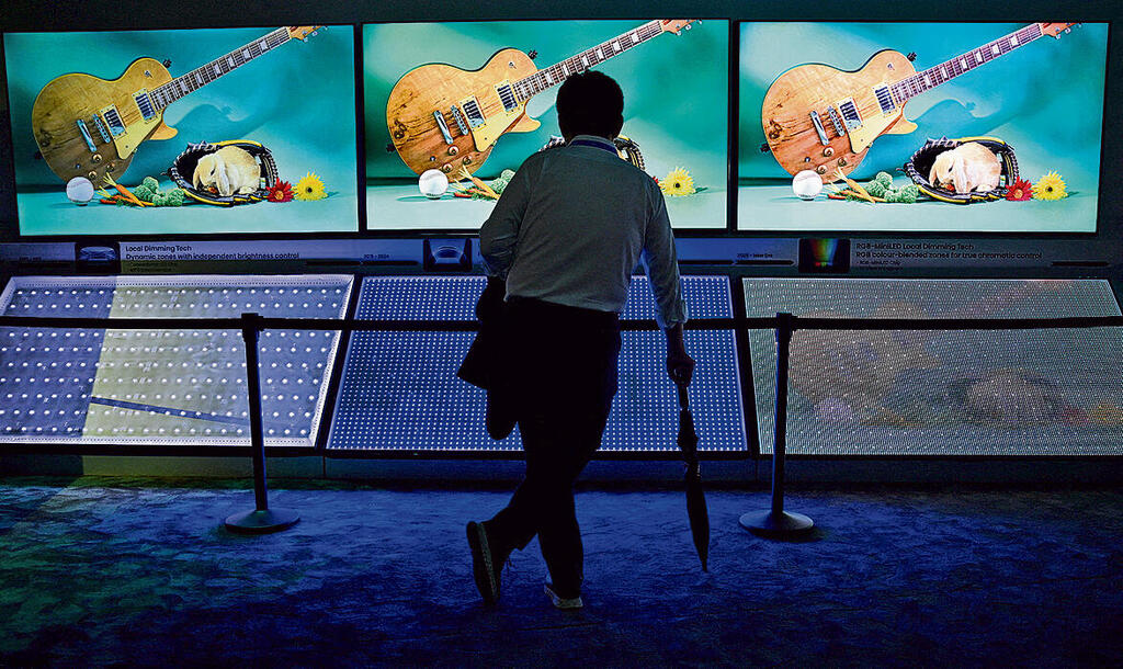 זו לעומת זו: צופה בתערוכה מול עמדת טלוויזיות "הייסנס". טכנולוגיות מסך חדשות | תצלום: רויטרס yk14505172