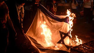 מפגינים שורפים את דגל ישראל בבוגוטה, קולומביה, ב-7 באוקטובר 2025