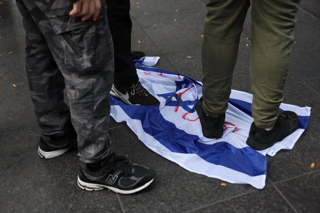 Pro-Palestinian activists trample an Israeli flag in New York on October 7, 2025 (Photo: Michael M. Santiago / Getty Images / AFP) פעילים פרו-פלסטינים דורכים על דגל ישראל בניו יורק, ב-7 באוקטובר 2025