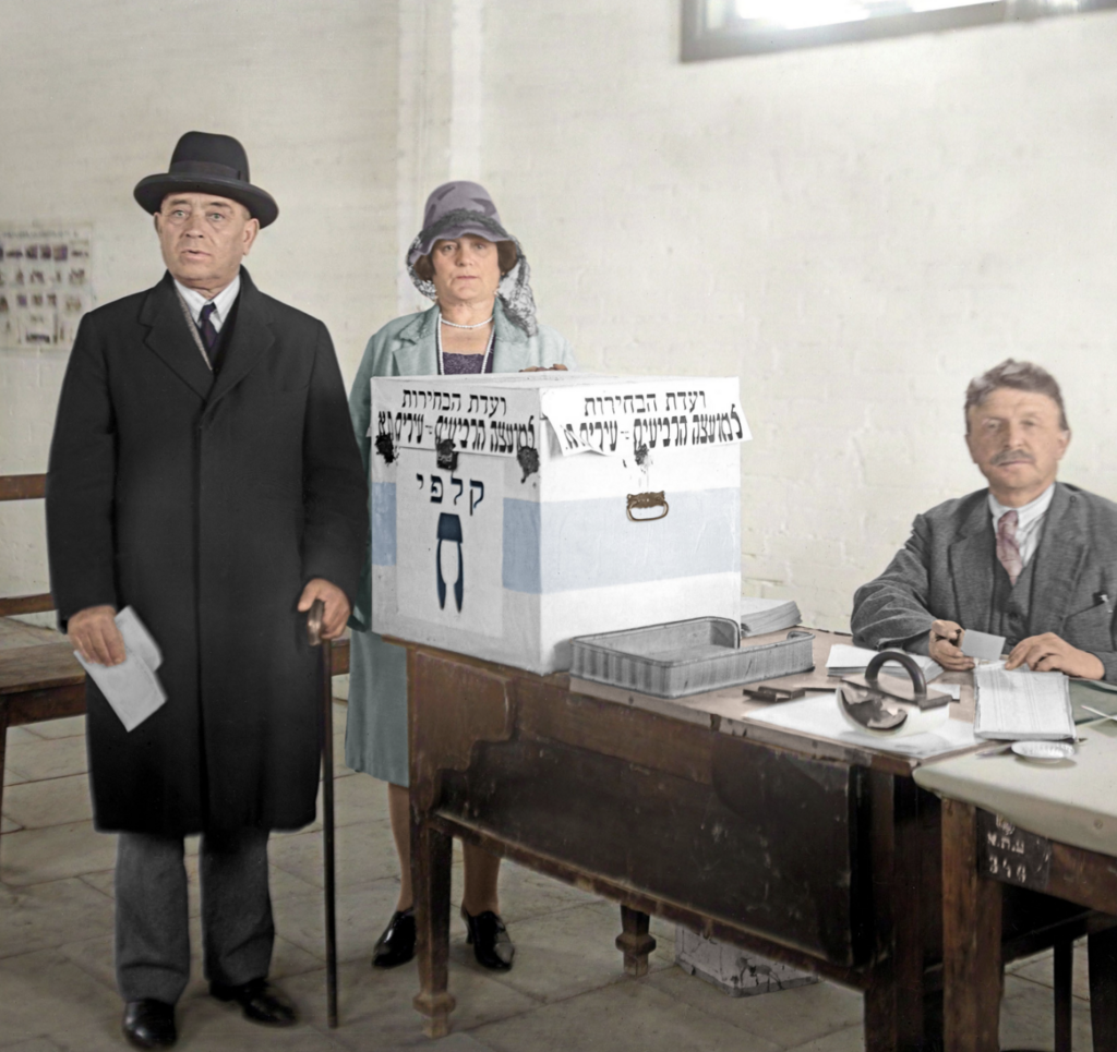 צינה ומאיר דיזינגוף בקלפי. הבחירות לראשות עיריית תל אביב, 31 דצמבר 1928 (צילום: יוסף שוויג, ארכיון הצילומים של קק"ל. צביעה: תמר הירדני) צינה ומאיר דיזינגוף בקלפי. הבחירות לראשות עיריית תל אביב, 31 דצמבר 1928