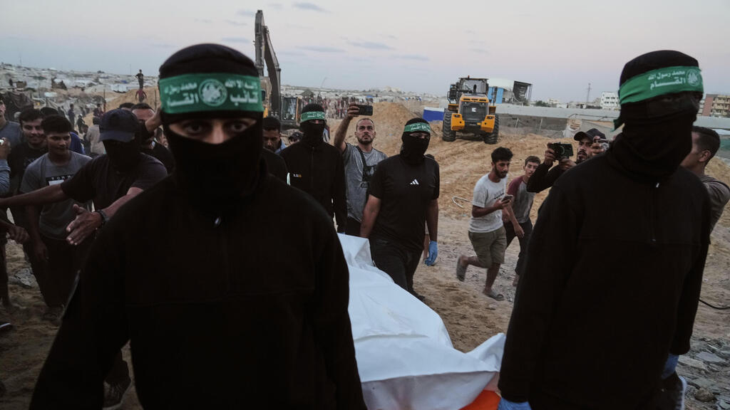 הודיעו ש"איתרו" חטוף חלל - ולא ישחררו. מחבלי חמאס בחאן יונס (צילום: AP Photo/Jehad Alshrafi) מחבלי חמאס מחלצים לכאורה שרידים של חלל חטוף בשכונת חמד חאן יונס רצועת עזה