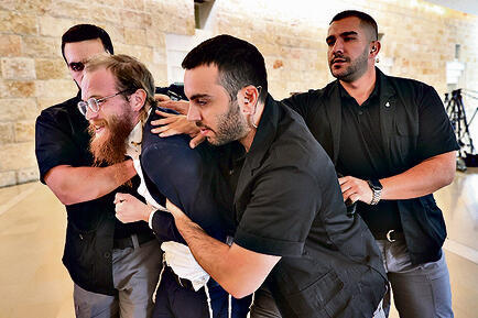 צעיר חרדי מוצא בכוח מאולם הדיון, אתמול | צילום: אלכס קולומויסקי yk14563212