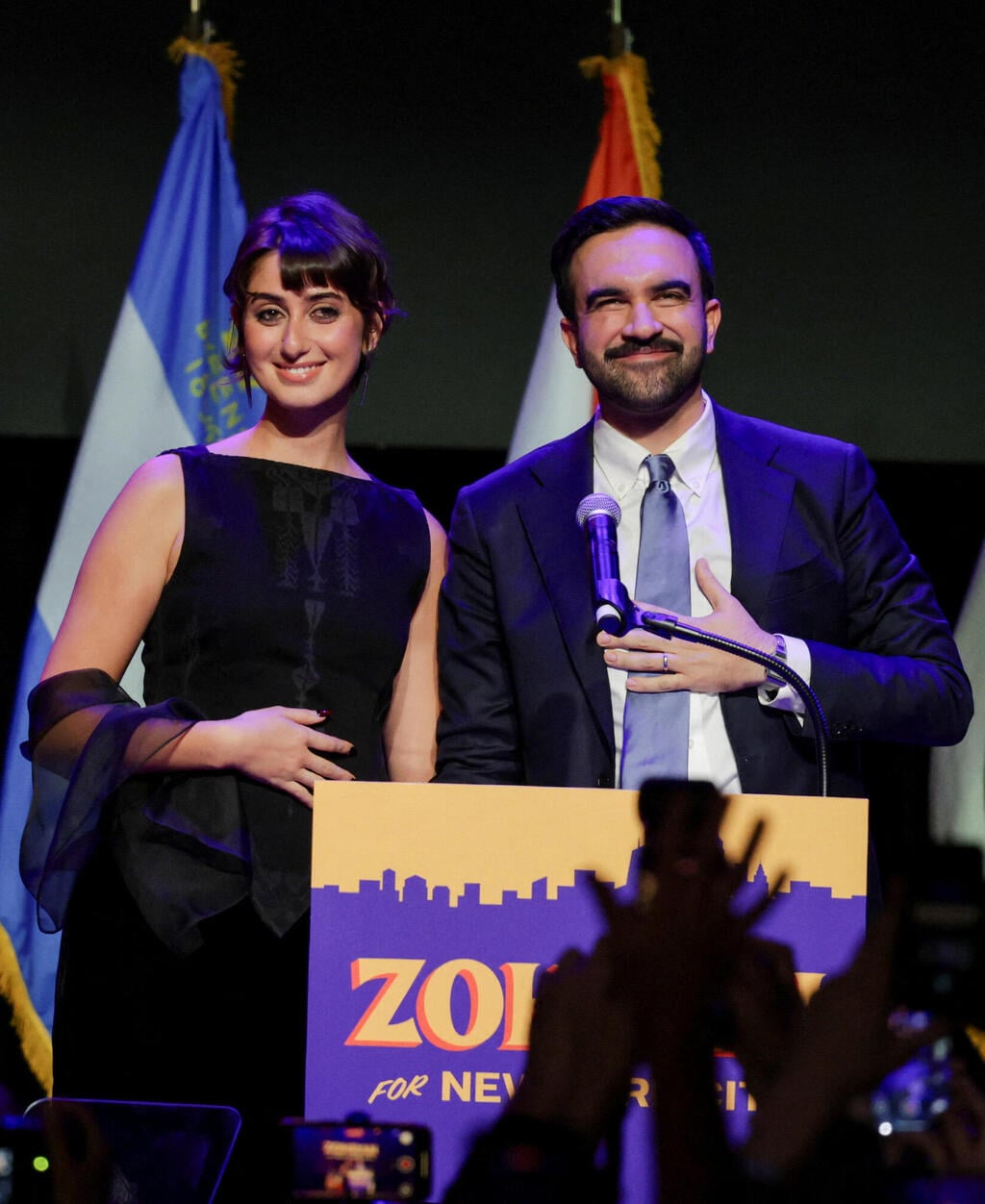 ראמה דוואג'י בחולצה של זאיד חיג'אזי וחצאית של אולה ג'ונסון (צילום: REUTERS/Jeenah Moon) ראמה דוואג'י וזוהרן ממדאני לאחר הניצחון בבחירות לראשות העיר ניו יורק, 2025