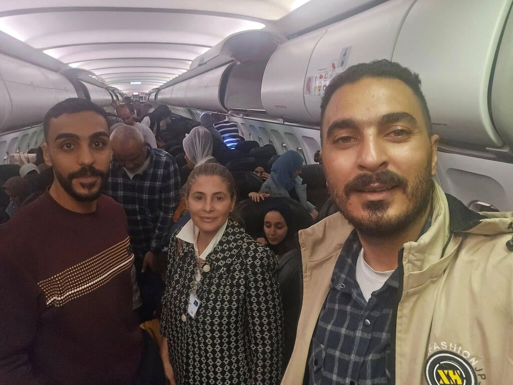 The Palestinian envoy to South Africa meets with Gazan passengers who arrived in Johannesburg on last month’s mysterious charter flight (Photo: Reuters) חנן ג'ראר, שגריר פלסטיני בדרום אפריקה, עם העזתים שהגיעו ליוהנסבורג בטיסה