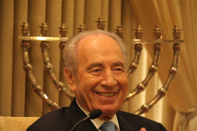 שמעון פרס ז"ל, נשיאהּ התשיעי של מדינת ישראל, כשברקע החנוכייה של משפחת ימיני