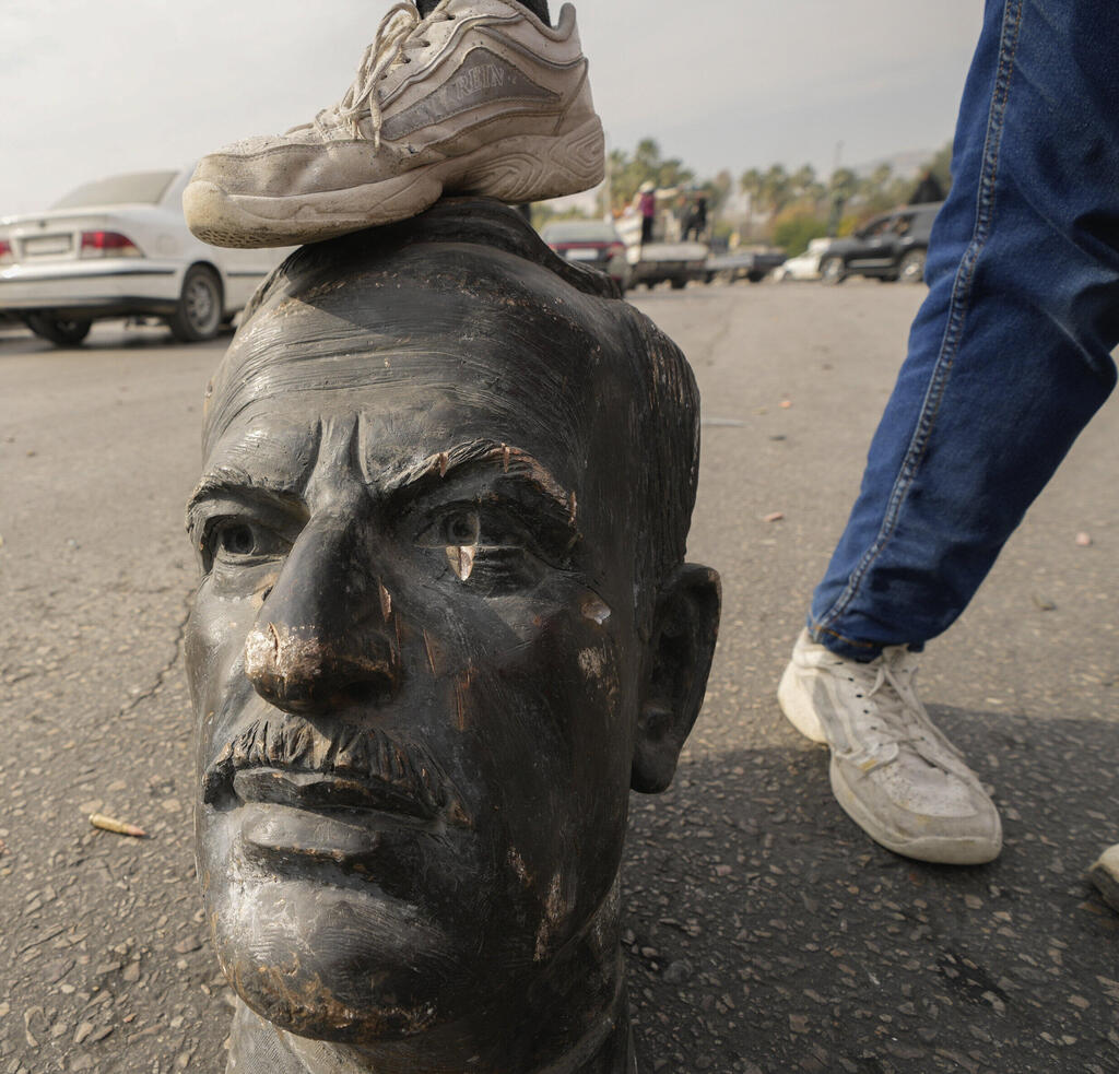 תושב דמשק דורך על "ראשו" של חאפז אסד ביום השחרור (Hussein Malla, AP) תושב דמשק דורך על "ראשו" של חאפז אסד ביום השחרור