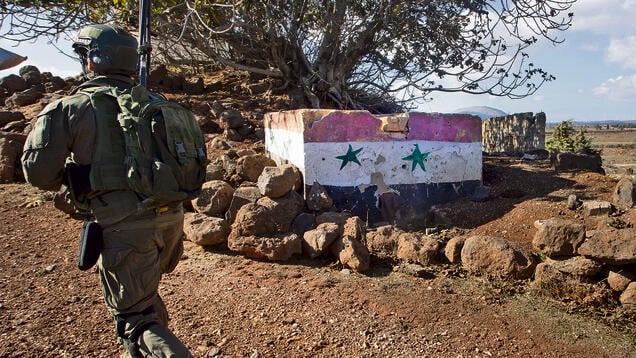 לוחם צה"ל ליד בטונדות עם דגלי סוריה. "המלחמה לא הסתיימה ואנחנו לא כאן כי כיף לנו" | צילום: גיל נחושתן