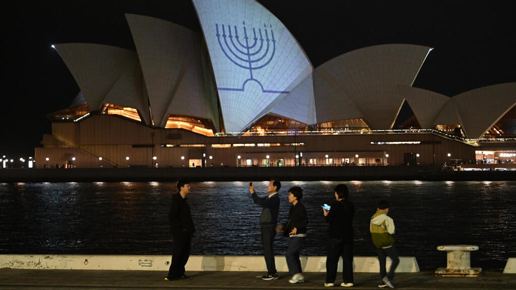 Sydney stands with Jewish community after massacre (Photo: James D. Morgan/Getty Images) בניין הואר עם ציור של חנוכייה לאחר הרצח בבונדיי ביץ'