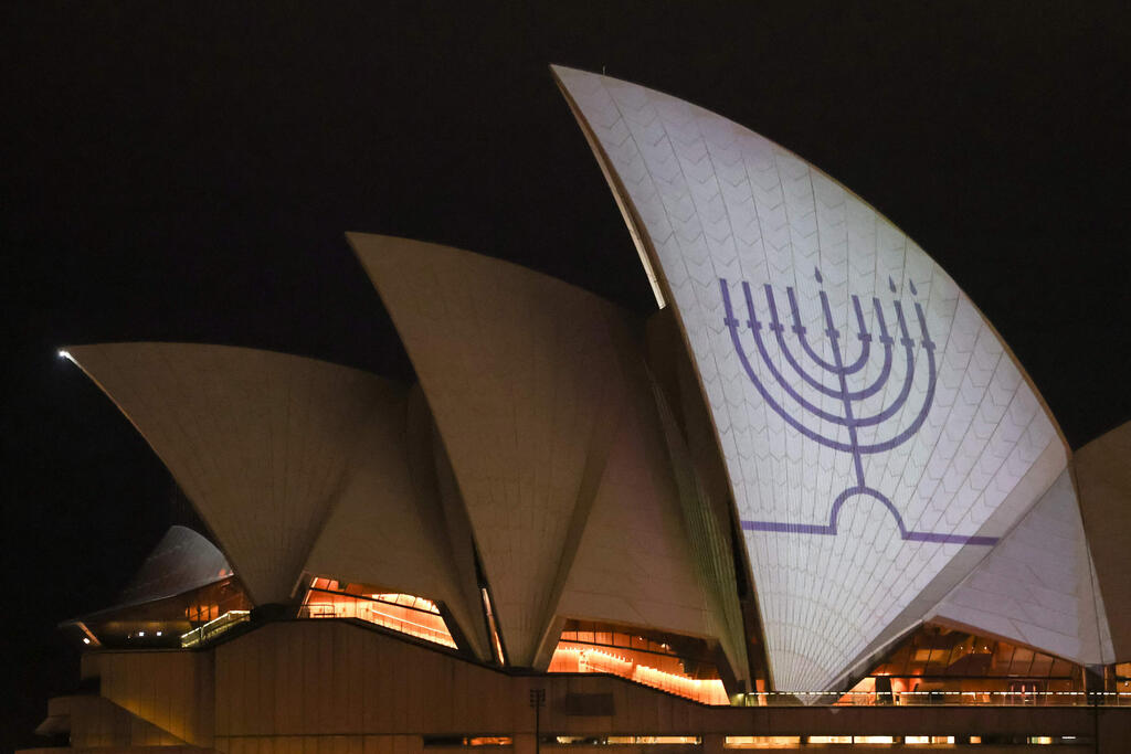 החנוכייה בבית האופרה (צילום: DAVID GRAY / AFP) בניין הואר עם ציור של חנוכייה לאחר הרצח בבונדיי ביץ'