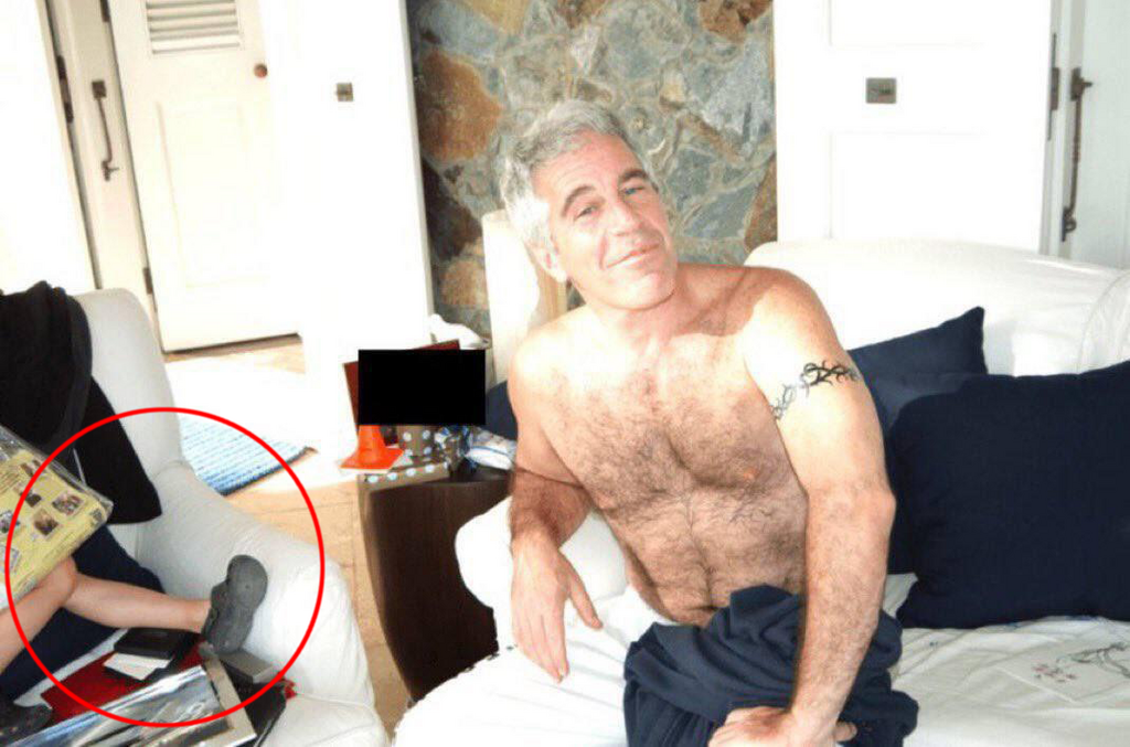Jeffrey Epstein is seen shirtless at his residence in an undated photo released by the U.S. Department of Justice. A partially visible leg next to him has sparked speculation online, though no confirmation has been provided about the individual’s identity ג'פרי אפשטיין בצילום שבו תועד לצד רגל של מישהו או מישהי לא מזוהים כחלק מפרסום מסמכי תיקי אפשטיין