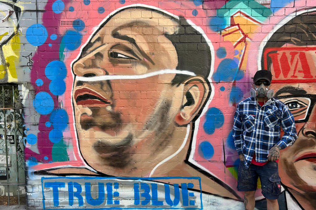 Street artist Jarrod Grech poses for a photo next to his painting of Ahmed al Ahmed, a 43-year-old Syrian-Australian shopkeeper who disarmed one of the attackers of Sydney's Bondi Beach shooting (Photo: Rod McGuirk/AP) Street artist Jarrod Grech poses for a photo next to his painting of Ahmed al Ahmed, a 43-year-old Syrian-Australian shopkeeper who disarmed one of the attackers of Sydney's Bondi Beach shooting