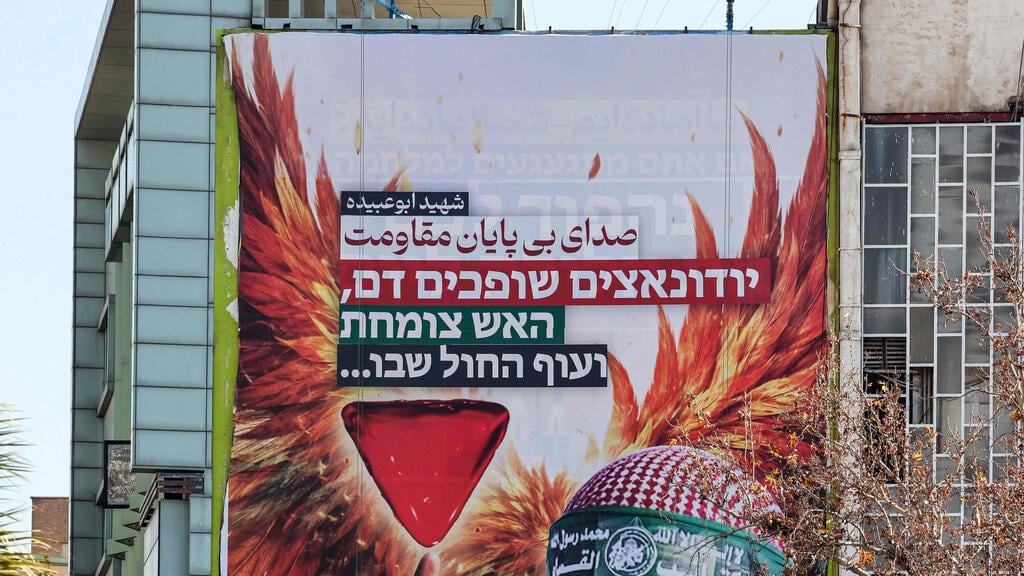Banner hung in Tehran’s Palestine Square reading: 'Judeo-Nazis spill blood, the fire grows, and the phoenix will return' (צילום: Atta Kenare / AFP) טהרן