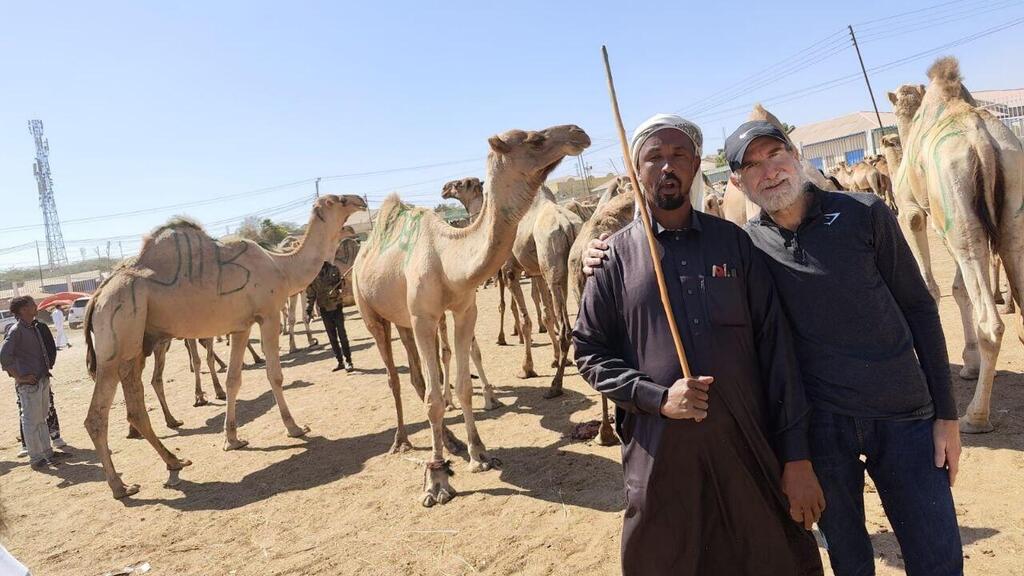 Chabad emissary Yanki Rubin with camels in the background in Somaliland שליח חב"ד ינקי רובין על רקע הגמלים בסומלילנד