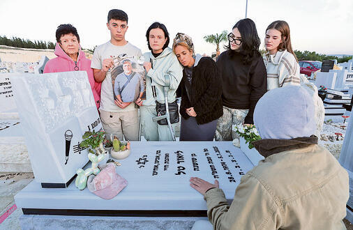 שנה בלעדיו. בני המשפחה בבית  העלמין