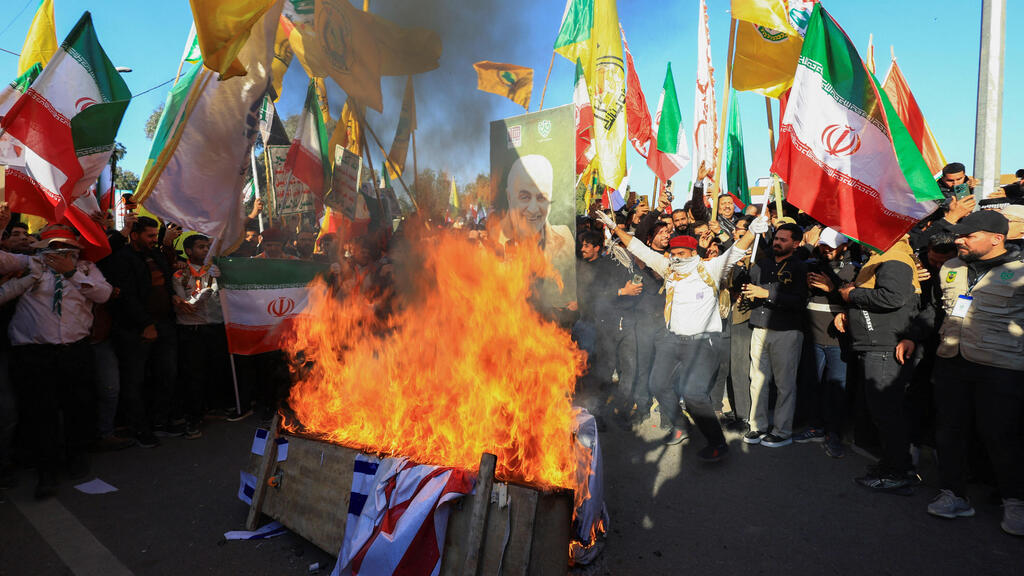 Supporters of the ayatollahs’ regime burn Israeli and US flags in Baghdad at midday (Photo: REUTERS/Thaier al-Sudani) הפגנת תומכי משטר האייתולות בבגדד