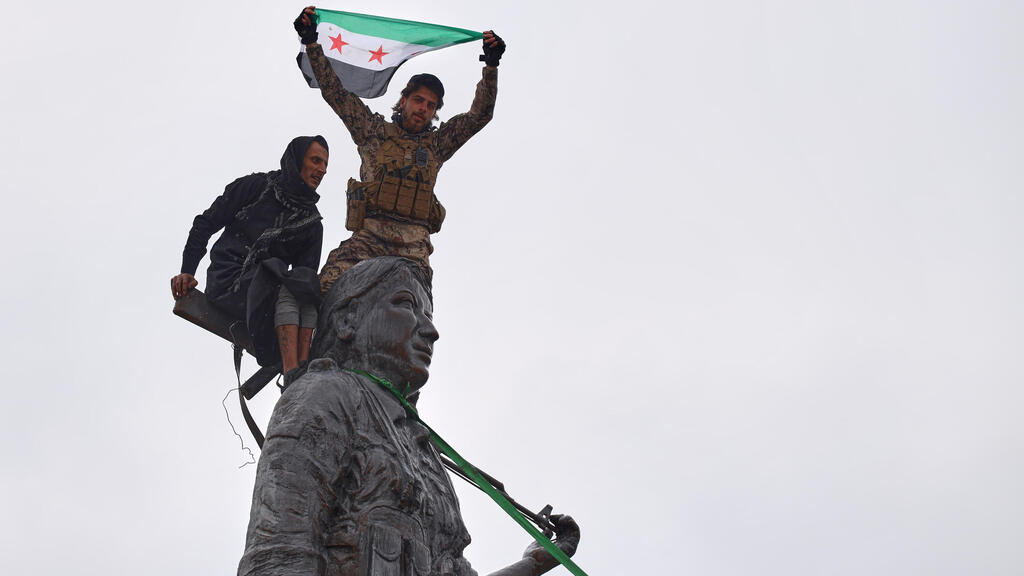 Syria Tabqa Supporters of the Sharia regime topple a statue of a Kurdish fighter after the withdrawal of Kurdish SDF forces from the city (Photo: Omar Albam/AP) סוריה א-טבקה תומכי משטר א-שרע מפילים פסל של לוחמת כורדית אחרי נסיגת כוחות כורדים SDF מהעיר