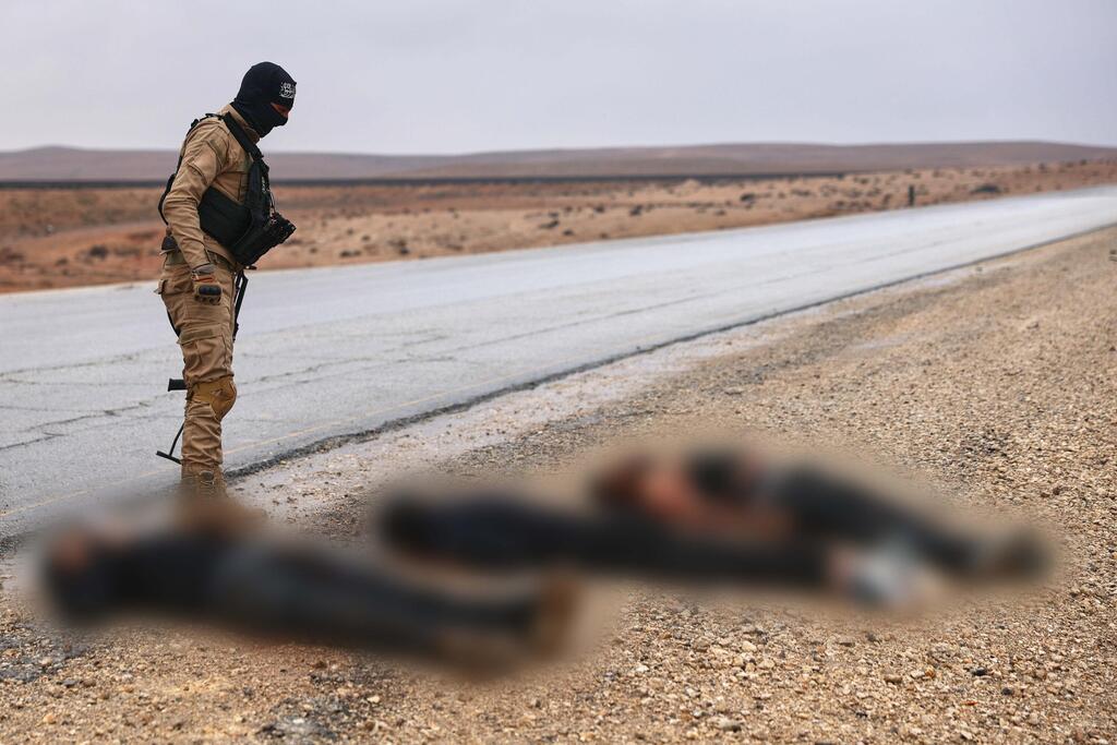 Syrian regime soldier stands over the bodies of Kurdish fighters in Tabqa, Raqqa province (Photo: AP Photo/Ghaith Alsayed) לוחם של משטר א-שרע צבא סוריה מעל גופות של לוחמים כורדים ב א-טבקה טבקה באזור א-רקה