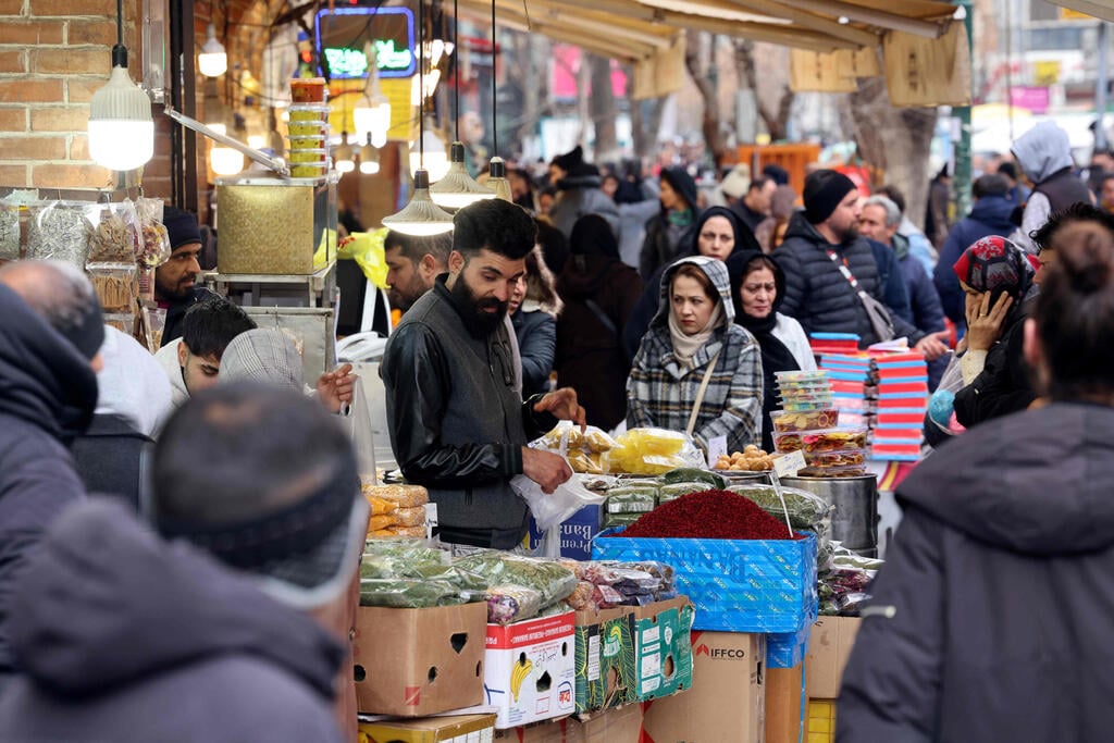 Iranians buying food at the bazaar in Tehran (Photo: ATTA KENARE / AFP) איראן קונים ב בזאר ב טהרן אוכל