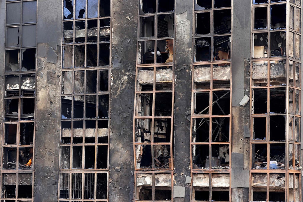 Photo: ATTA KENARE / AFP איראן נוסעים ליד בניין ש נשרף ב מחאה ב טהרן