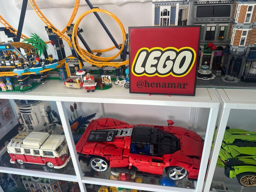A large LEGO roller coaster towers over Hen Amar’s display shelves, featuring a custom LEGO logo sign and Technic Ferrari below (Photo: Bar Gindy) A large LEGO roller coaster towers over Chen Amar’s display shelves, featuring a custom LEGO logo sign and Technic Ferrari below