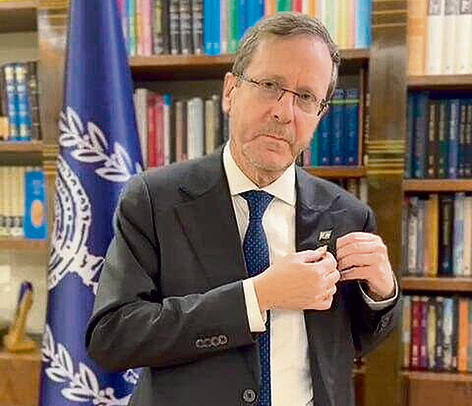 אקט סמלי: נשיא המדינה, יצחק הרצוג, מסיר מחליפתו את סיכת החטופים, אחרי החזרתו של גואילי, אתמול