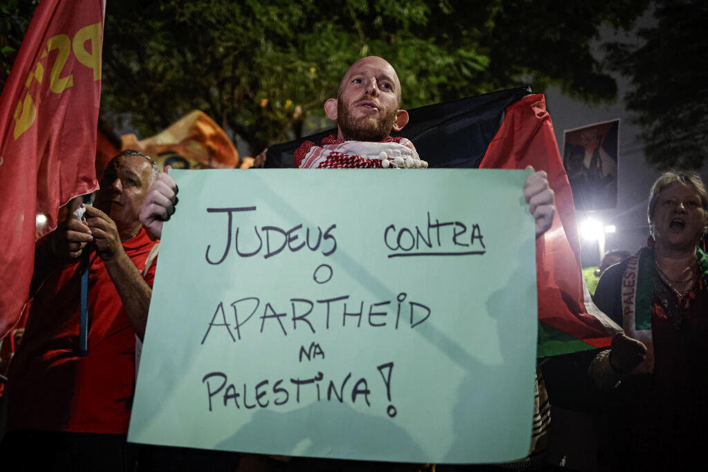 חבר הקהילה היהודית בברזיל נושא שלט שקורא "להפסיק את מדיניות האפרטהייד של ישראל נגד הפלסטינים" (צילום: Tuane Fernandes/AP) חבר הקהילה היהודית בברזיל נושא שלט שקורא "להפסיק את מדיניות האפרטהייד של ישראל נגד הפלסטינים"