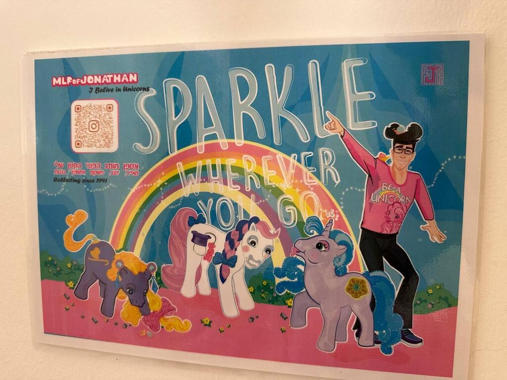 A poster reading 'Sparkle wherever you go' hangs above shelves filled with collectible ponies in Jonathan’s display room (Photo: Bar Gindy) A poster reading 'Sparkle wherever you go' hangs above shelves filled with collectible ponies in Jonathan’s display room