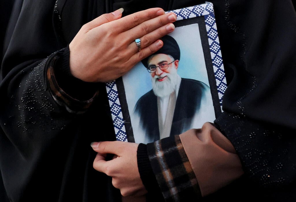Woman holds a portrait of slain Iranian Supreme Leader Ayatollah Ali Khamenei at a memorial rally in Tehran (Photo: Majid Asgaripour/WANA (West Asia News Agency) via REUTERS) טהרן איראן אישה בוכה אחרי חיסול עלי חמינאי