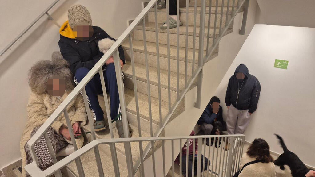 יש מי שנפגעים יותר בשגרת האזעקות. בתמונה: תופסים מחסה בחדר המדרגות (צילום: מוטי קמחי ) חדר מדרגות בתל אביב בזמן האזעקות