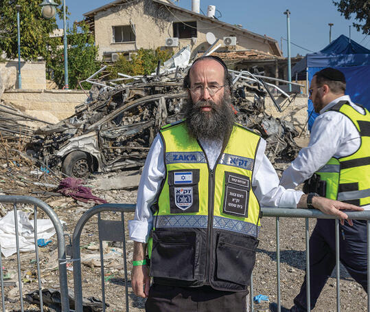 אברהם קאפ, ראש זק"א בית שמש, ומאחוריו שרידי מכוניתה של רונית ז"ל. "הייתי בהרבה זירות, זו קשה במיוחד" | צילום: יובל חן