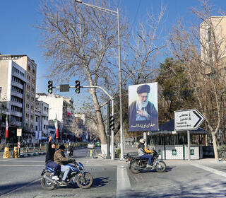 V של שמחה ליד שלט לזכר חמינאי, השבוע בטהרן. השינוי עובר בהפלת המשטר שרצח יותר ממיליון איש באזור | צילום: REUTERS/Majid Asgaripour