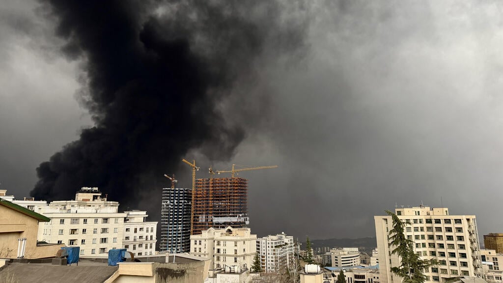 Smoke over Tehran after Israeli strike (Photo: Majid Saeedi/Getty Images) עשן בשמי טהרן בבוקר אחרי שישראל תקפה מחסני דלק