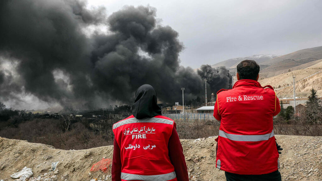 Smoke rises after strike on Shahran oil depot in Iran during (Photo: AFP) עשן אחרי תקיפה של מאגר נפט שהראן איראן מבצע שאגת הארי