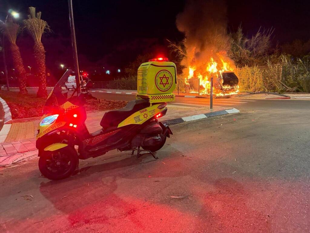צילום: דוברות מד"א רכב שהתנגש בגדר ועלה באש במהלך אזעקה בשדרות יצחק רבין בנס ציונה