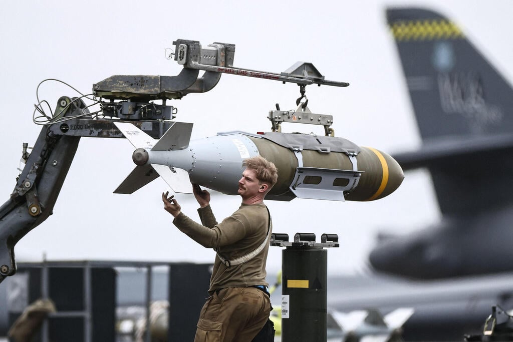צילום: Henry NICHOLLS / AFP חייל אמריקני מכין פצצה חודרת בונקרים JDAM לצד מפציצים מפציץ B-1B של חיל האוויר של ארה"ב לקראת הפצצות ב איראן ב בסיס אווירי ב פיירפורד בריטניה