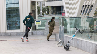 רצים לתפוס מחסה בתחנת הרכבת הקלה בשעת אזעקה בתל אביב במהלך ימי שאגת הארי