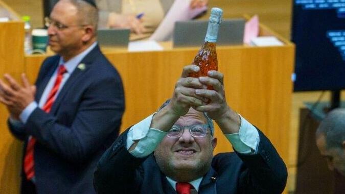 איתמר בן גביר במליאת הכנסת לאחר ההכרזה על אישור חוק עונש מוות למחבלים עם שמפניה בידו